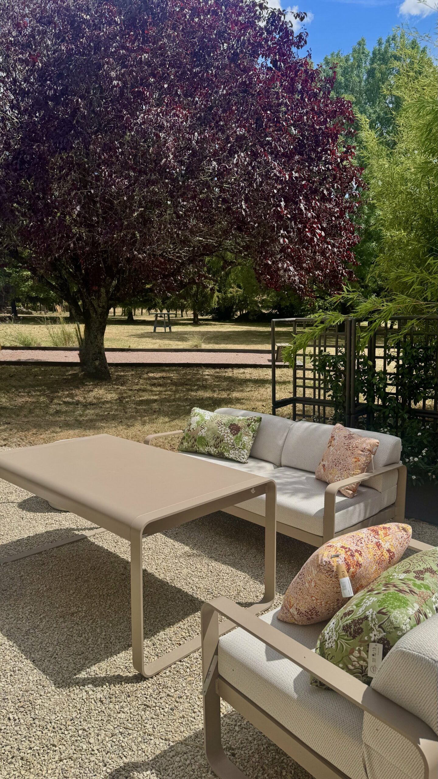 Salon low dining Fermob Bellevie coloris muscade, canapé et table dans un jardin