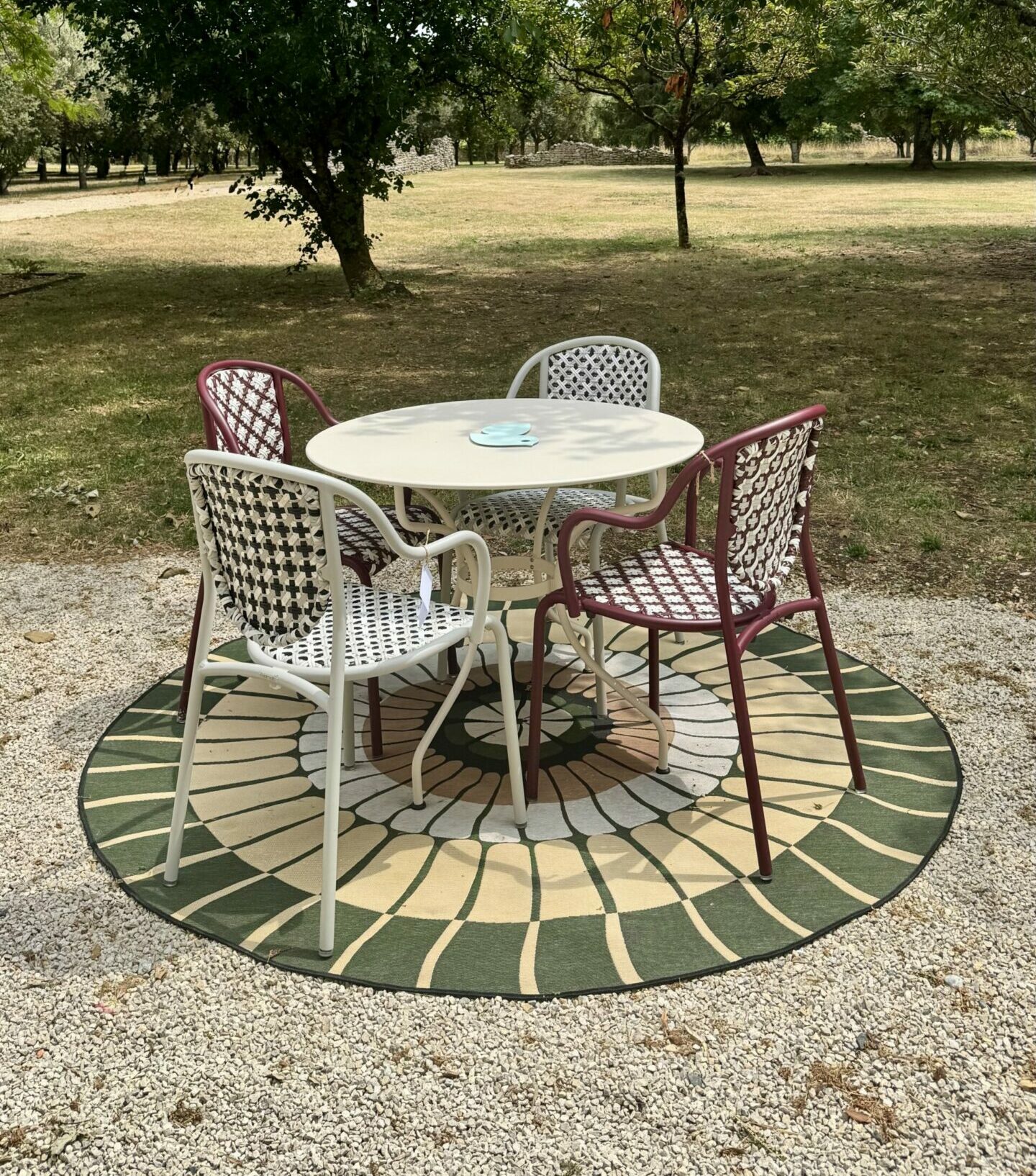 Salon de jardin Fermob avec chaises La Parisienne blanches et bordeaux, table ronde