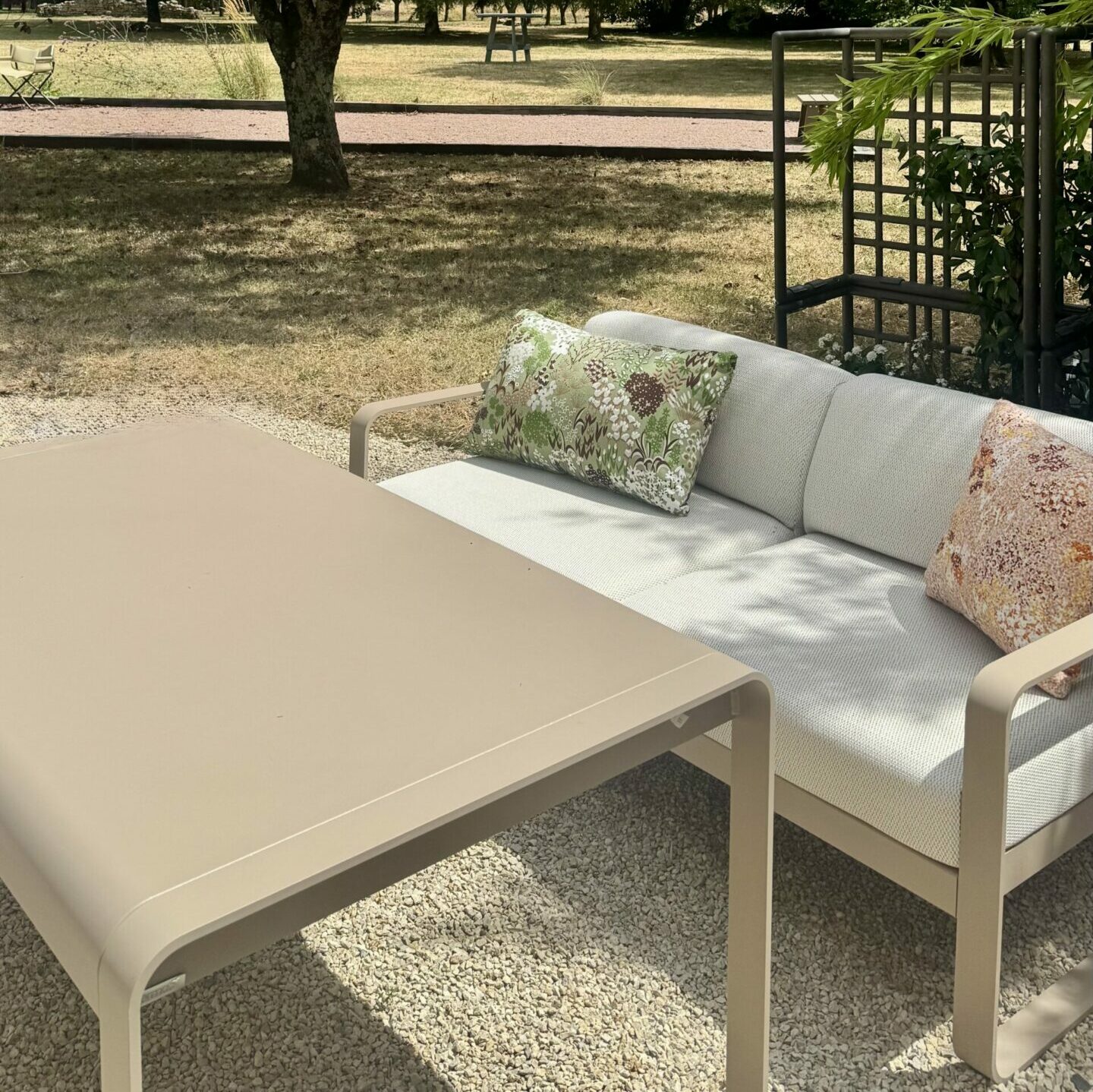 Salon low dining Fermob Bellevie coloris muscade, canapé et table dans un jardin